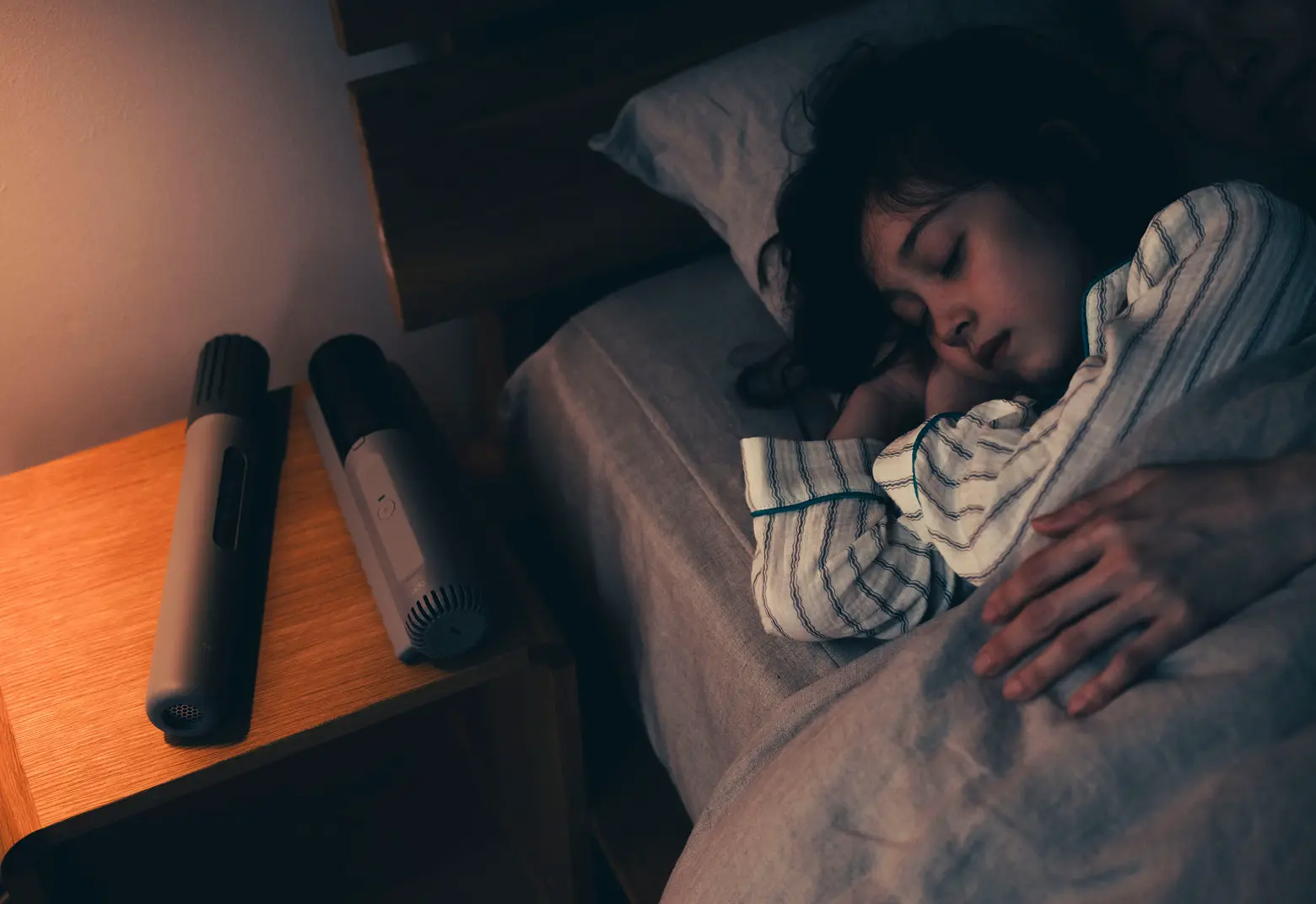 FOEHNふとん乾燥機とFOEHN Cleanerのそばで眠る女性